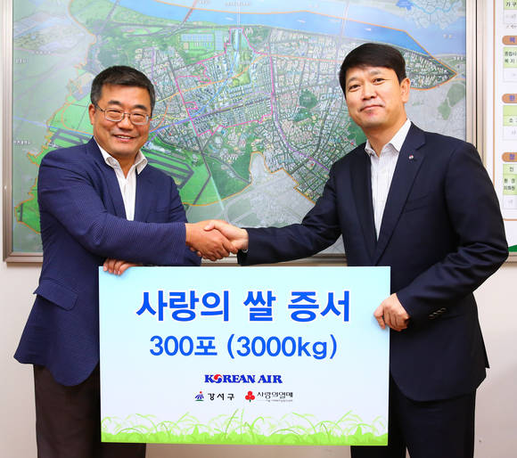 ▲ 대한항공 '사랑의 쌀' 기증행사에 참석한 대한항공 이석우 총무부 담당 상무(오른쪽)와 강서구청 김진선 생활복지국장이 기념 사진을 찍는 모습.ⓒ대한항공