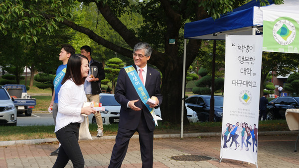 ▲ 홍덕률 총장이 등교하는 학생들에게 떡과 음료를 전달하고 있다.ⓒ대구대 제공