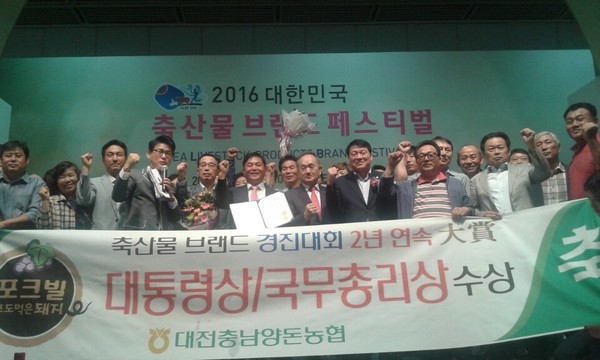 ▲ 대전충남양돈농협 관계자 등이 8일 2016년 최고의 축산물 브랜드로 선정돼 상을 받은 뒤 기념촬영을 하고 있다.ⓒ충남도