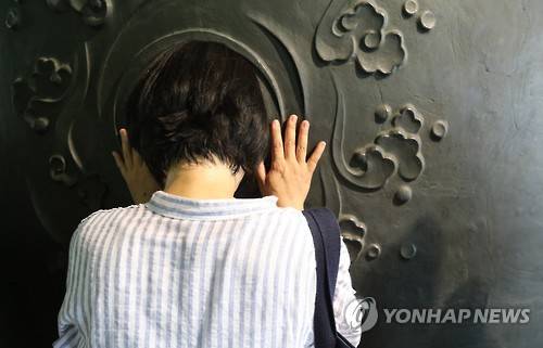 ▲ 지난달 9일 서울 보신각에서 열린 '제5회 대학 합격 타종행사'에서 수험생 자녀를 둔 한 학부모가 기도를 하고 있다.ⓒ연합뉴스