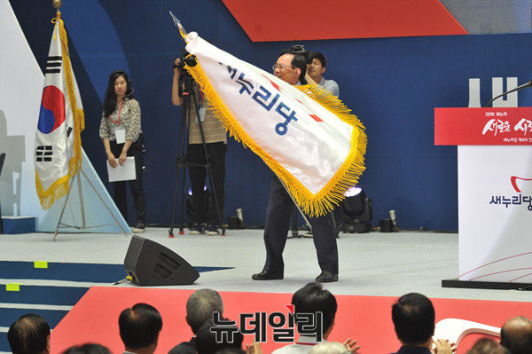 ▲ 경남 권역의 최다선 의원인 새누리당의 5선 중진 이주영 의원이 지난달 9일 전당대회장에서 당기를 휘두르고 있다. 이주영 의원은 득표율 3위에 그쳐 당대표 경선에서 낙선의 고배를 마셨다. ⓒ뉴데일리 이종현 기자