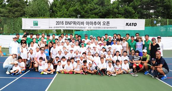 ▲ '2016 BNP파리바 아마추어 오픈' 무료 어린이 테니스 교실에 참여한 강사진과 어린이, 한국BNP파리바, BNP파리바 카디프생명 임직원 자원봉사자들이 단체사진을 촬영하고 있다. ⓒBNP파리바카디프생명