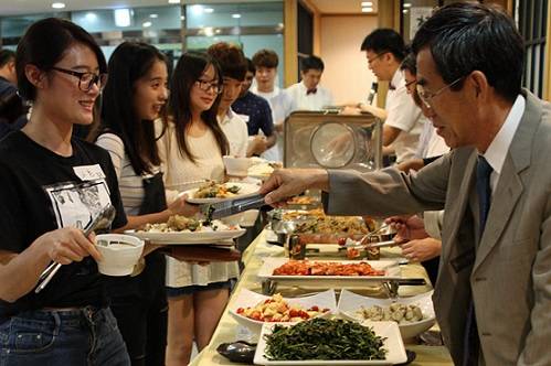 12일 서울 노원구 광운대학교에서 진행된 '추석맞이 한가위 행사'에서 대학 관계자가 외국인 학생에게 음식을 건네고 있다. ⓒ광운대
