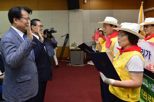 ▲ 제천한방바이오박람회 자원봉사자 대표가 이근규 시장(왼쪽)에게 성공 개최 다짐을 하고 있다.ⓒ제천시