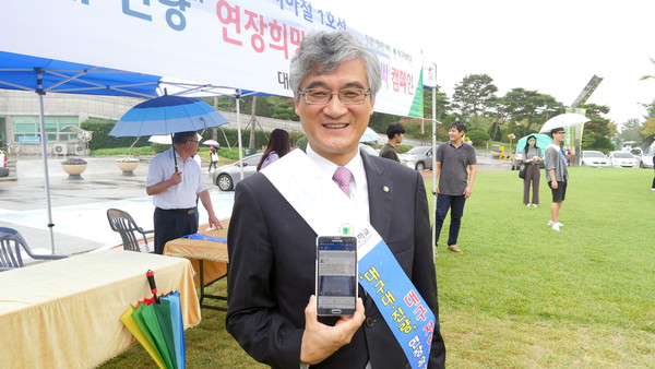 ▲ 지하철 대구대·진량 연장 촉구 손글씨 릴레이 캠페인 첫 주자로 나선 홍덕률 총장이 직접 쓴 손글씨를 자신의 페이스북에 올린 후 기념사진을 찍고 있다.ⓒ대구대 제공