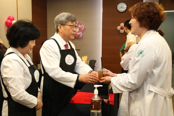 ▲ 김승철 이화의료원장(사진 가운데)과 박은애 기획조정실장(사진 왼쪽)이 바리스타로 변신해 직원들에게 커피와 아이스티를 만들어 제공하고 있다.ⓒ이대목동병원