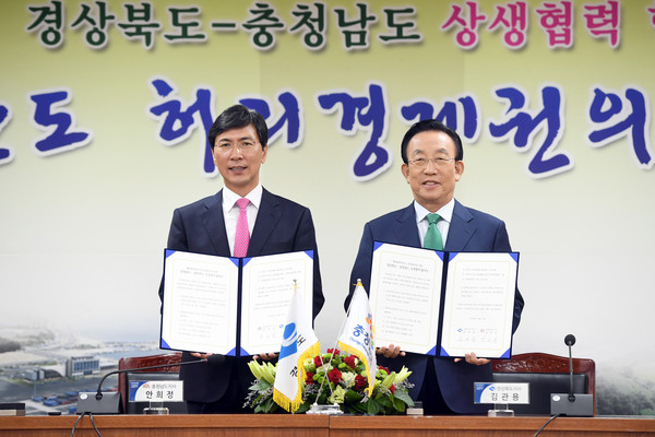▲ 김관용 경북도지사(오른쪽)와 안희정 충남지사가 10일 경북도청에서 상생협력을 위한 '경북-충남 상생협약식'을 개최하고 협약서를 들어보이고 있다.ⓒ경북도 제공