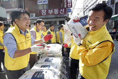 ▲ 김한기 대림산업 대표가 사랑의 쌀 배달을 위해 포대자루를 짊어지고 있다. ⓒ 대림산업