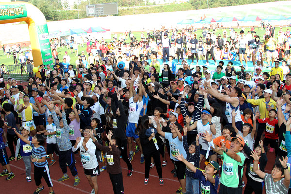 ▲ 지난해 마라톤대회 출발 전, 주최측이 나눠주는 싸인볼을 잡기 위해 참가자들이 팔을 치켜들고 있다.ⓒ단양군