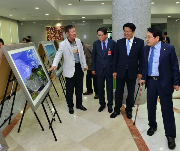 ▲ 국회 의원회관에서 열린 '제천관광사진전'을 둘러보고 있는 국회의원들.ⓒ제천시