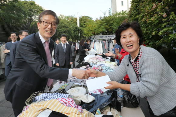 ▲ 19일 이동걸 산업은행 회장이 서울 여의도 본점 앞에서 삼성농아원과 함께 연 ‘사랑 나눔 바자회’에서 물건을 구매하고 있다. ⓒ 산업은행