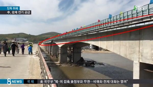 ▲ 지난 25일 SBS는 "중국이 북한에 몰래 전기를 공급하고 있다"고 보도했다. 붉은 동그라미 속 검은 선이 고압 송전선이다. ⓒSBS 관련보도 화면캡쳐