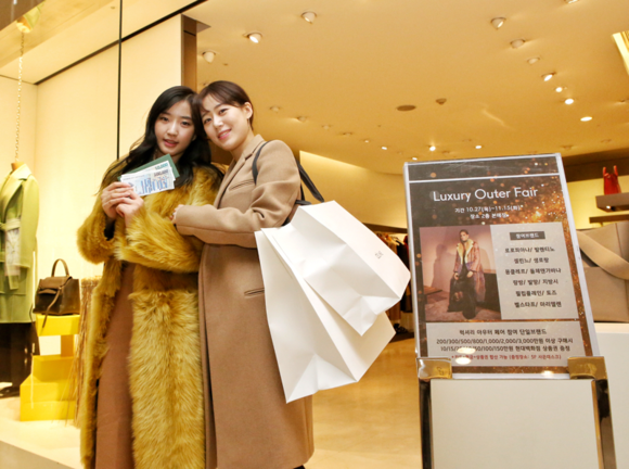 ▲ 현대백화점 고객이 아우터 구매후, 받은 상품권을 들고있다. ⓒ현대백화점