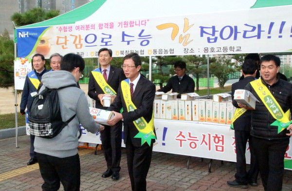 ▲ 경남농협 직원들이 10일 창원 용호고교에서 고 3학생들을 대상으로 단감으로 수능 감 잡아라 캠페인을 전개하고 있다.ⓒ경남농협 제공