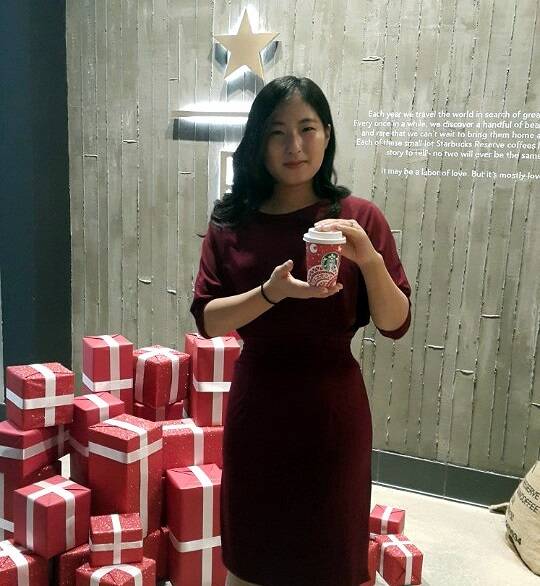 ▲ 권은주 씨가 디자인한 스타벅스 '레드 컵'을 손에 들고 웃고 있다. ⓒ스타벅스커피 코리아