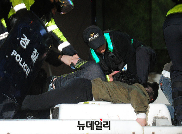 ▲ 지난 12일 오후 10시를 넘은 시간, 극소수 시위대는 서울 종로구 청운·통인 주민센터 앞에 설치한 차벽을 넘어 청와대로 침입하려다 경찰들에 의해 제지를 당했다. 경찰은 이들을 연행하지 않고 다시 안전하게 차벽에서 내려갈 수 있도록 유도하는 인내심을 보여줬다. ⓒ뉴데일리 DB