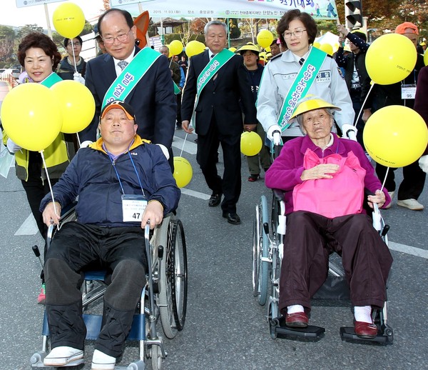 ▲ 류한우 군수(왼쪽 두번째)가 장애인의 날 행사에서 휠페어를 끌며 장애인식 개선 홍보활동을 벌이고 있다.ⓒ단양군