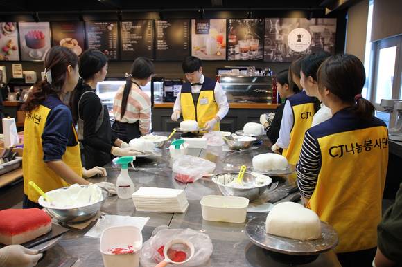 지난 19일 서울 금천구 가산동에 위치한 CJ푸드빌 아카데미에서 재능나눔 프로그램으로 열린 '행복나눔데이-커피&디저트교실'에 참석한 청소년들이 전문강사들과 '투썸요거하트케이크'를 만들고 있다. ⓒCJ푸드빌