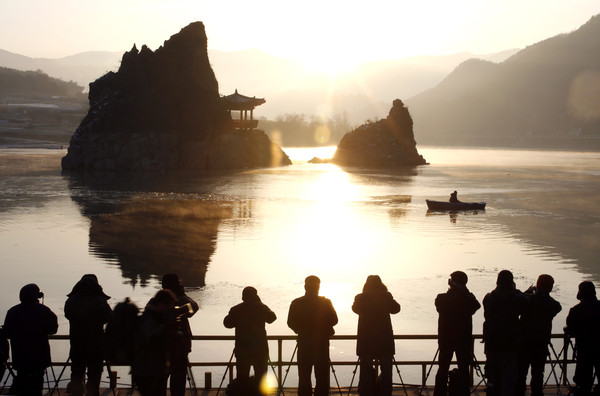 ▲ 이른 아침, 도담삼봉을 배경으로 일출 모습을 렌즈에 담고 있는 사진동호인들 모습.ⓒ단양군