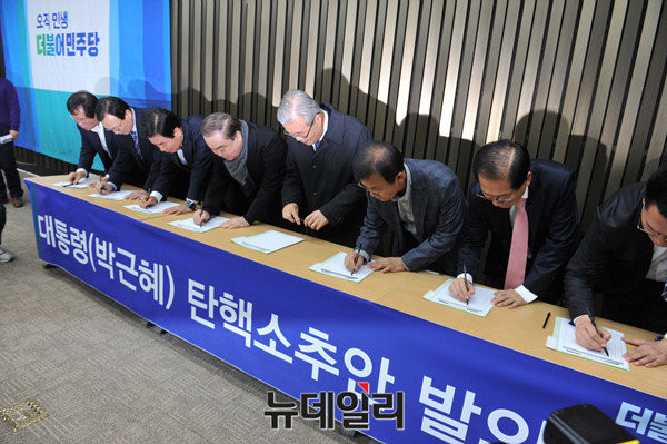 ▲ 29일 오후 박근혜 대통령의 대국민 담화 직후 국회에서 열린 더불어민주당 의원총회에서 의원들이 '대통령 박근혜 탄핵 소추안 발의'에 서명하고 있다.ⓒ이종현 기자