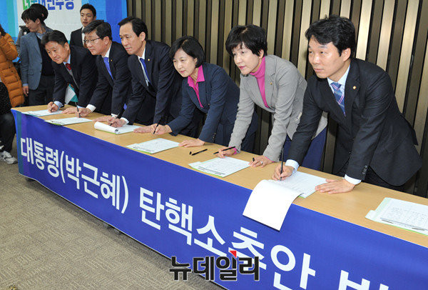 ▲ 더불어민주당 추미애 대표와 우상호 원내대표 등이 박근혜 대통령에 대한 탄핵소추안 발의를 위해 서명하고 있다. ⓒ뉴데일리 이종현 기자