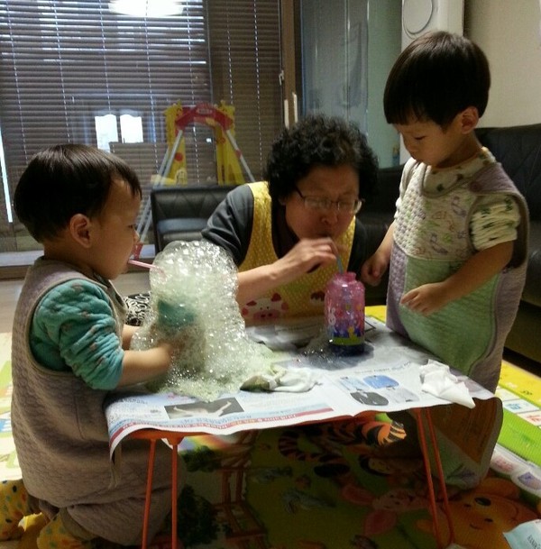 ▲ 아이돌보미가 아이들과 함께 비누거품놀이를 하고 있다.ⓒ제천시