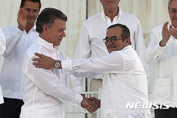 ▲ 지난 9월 26일(현지시간) 평화협정에 서명한 뒤 악수를 나누는 후안 마누엘 산토스 콜롬비아 대통령(왼쪽)과 공산반군 FARC 지도자(오른쪽). 이 평화협정은 그러나 국민투표에서 부결됐다. ⓒ뉴시스. 무단전재 및 재배포 금지.