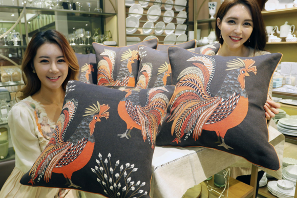 ▲ 모델들이 붉은 닭 문양이 들어간 쿠션을 들고 포즈를 취하고 있다. ⓒ신세계