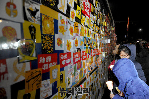 ▲ 광화문광장에 주차된 경찰버스에, 퇴진행동 측이 나눠준 각종 스티커를 붙이고 있는 시민들. ⓒ뉴데일리 이종현 기자