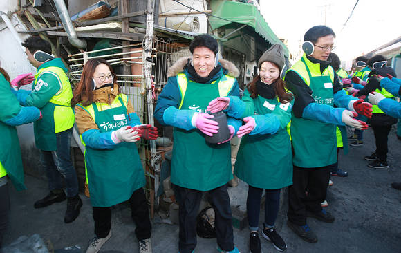 ▲ 지난 14일 함영주 KEB하나은행장(사진 가운데)이 봉사활동에 참여한 하나은행 및 하나금융그룹 관계사 임직원, 스마트홍보대사들과 ‘사랑의 연탄’을 전달하고 있다.ⓒKEB하나은행