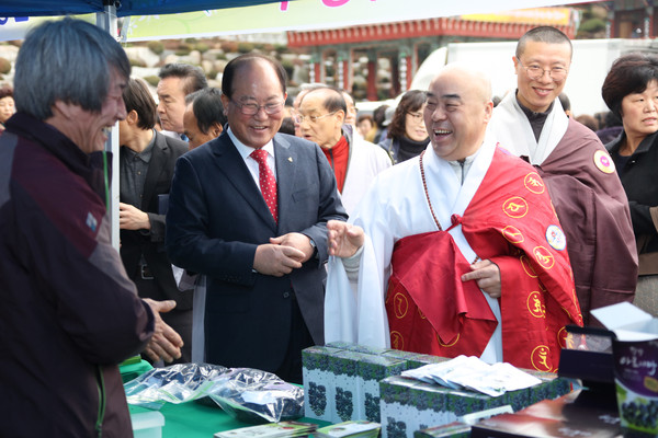 ▲ 지난해 부산 삼광사에서 열린 단양농특산물 직거래행사에 참여한 류한우 군수와 무언스님이 농가들과 이야기를 나누고 있다.ⓒ단양군