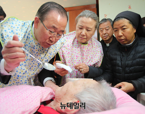 ▲ 반기문 전 유엔사무총장이 14일 음성꽃동네에서 거동이 불편한 할머니에게 미음을 조금씩 떠먹이고 있는 모습. 배우자 유순택 여사는 옆에서 손수건을 꺼내 입 주변을 닦아주고 있다. 꽃동네 측 안내 수녀가 바로 옆에서 상황을 지켜보면서 봉사 방식을 지도하고 있는 모습이다. ⓒ사진공동취재단