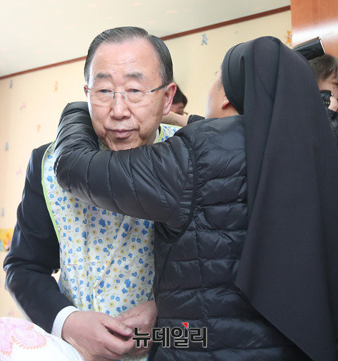 ▲ 반기문 전 유엔사무총장이 14일 음성꽃동네에서 봉사 활동에 나서기에 앞서, 수녀로부터 턱받이 앞치마를 착용받고 있다. ⓒ사진공동취재단