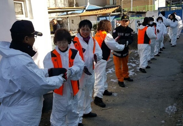 ▲ 제천여성의용소방대 회원들이 차량이 진입할 수 없는 산곡동 노인세대에 연탄을 나르고 있다.ⓒ제천소방서