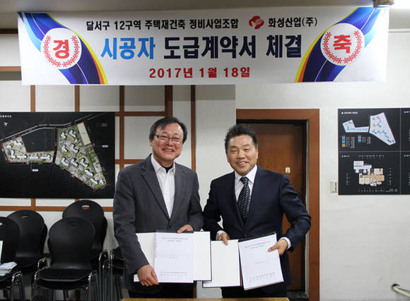 ▲ 도훈찬 화성산업 상무이사(좌)와 김병석 달서구 12구역 주택재건축정비사업 조합장이 기념촬영을 하고 있다. ⓒ화성산업