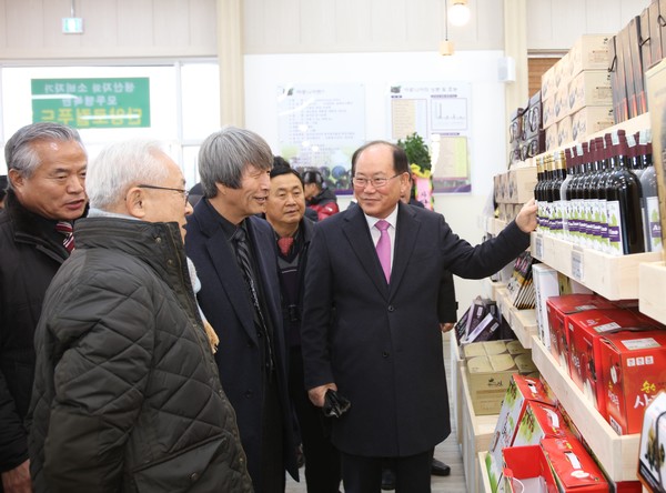 류한우 군수(오른쪽)와 농산물 생산 농가들이 판매장을 둘러보고 있다.ⓒ단양군
