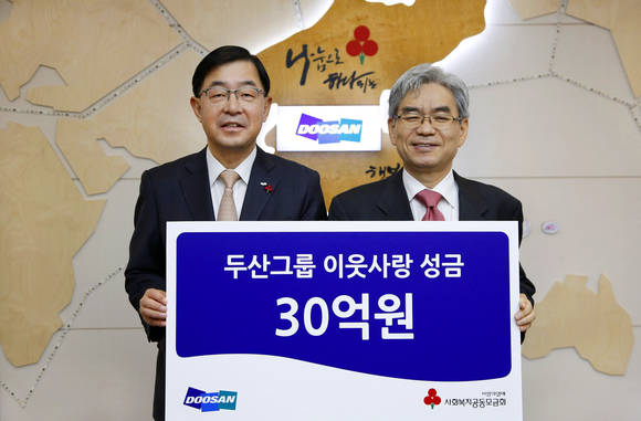 ▲ 박완석 ㈜두산 부사장(왼쪽)이 박찬봉 사회복지공동모금회 사무총장에게 성금을 전달하고 있다.ⓒ두산그룹