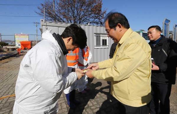 ▲ 이승훈 충북 청주시장이 설 연휴 첫날인 지난 27일 AI거점소독소를 방문해 근무자들에게 핫팩을 전달하며 위로하고 있다.ⓒ청주시