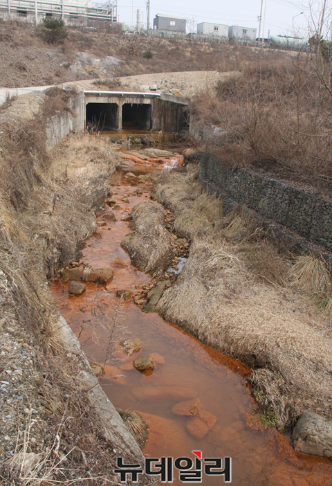 제천왕암동 폐기물매립장에서 흘러 들어온 침출수 등으로 산업단지 하류 하천이 붉은 모습으로 오염된 모습.ⓒ목성균 기자