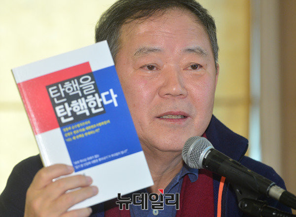 ▲ 대한변협 회장을 지낸 김평우 변호사. 대통령에 대한 국회 탄핵소추의 위헌성을 지적한 저서 '탄핵을 탄핵한다'를 들어보이고 있다. ⓒ 뉴데일리 공준표 기자