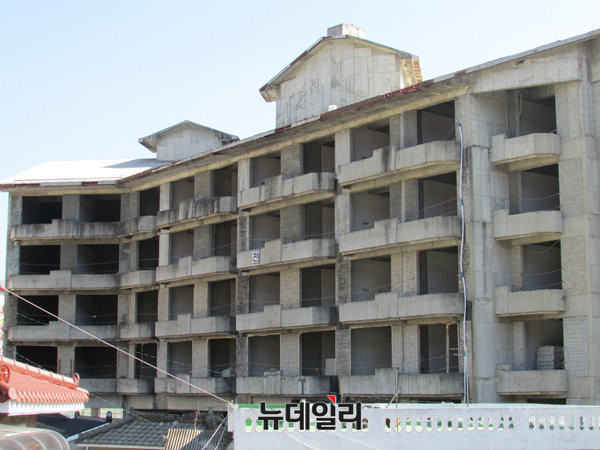 ▲ 국내 최고의 온천관광지로서의 위용을 자랑했던 충북 충주 수안보 중심가에 12일 한 건물이 짓다 만 상태로 흉물스럽게 방치돼 있다. 공사장의 안전제일 표지마저 다 떨어져나가고 전 자만 위태롭게 붙어 있다. ⓒ충주(충북)=뉴데일리 정도원 기자