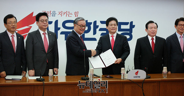 ▲ 자유한국당 인명진 비대위원장과 김진 전 중앙일보 논설위원이 입당원서를 주고받으며 악수하고 있다. ⓒ뉴데일리 정상윤 기자