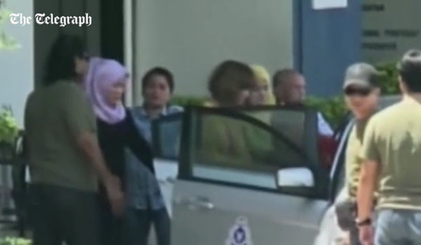 말레이시아 경찰에 의해 호송되는 용의자. 히잡을 쓰지 않은 여성이 용의자다. ⓒ英텔레그라프 관련보도 화면캡쳐