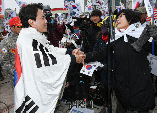 ▲ 자유한국당 김진태 의원(왼쪽)에 악수를 하기 위해 팔을 내미는 태극기 집회 참가자. ⓒ뉴데일리 정상윤 기자