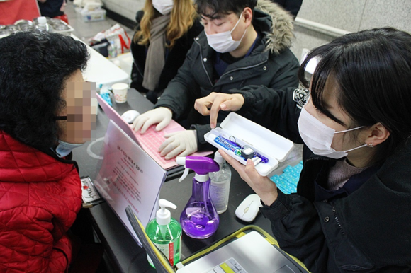 ▲ 봉사단이 무료진료소를 방문한 주민에게 무료 검진을 실시한 후, 유디치과에서 후원한 구강용품을 전달 하고 있다.ⓒ유디치과