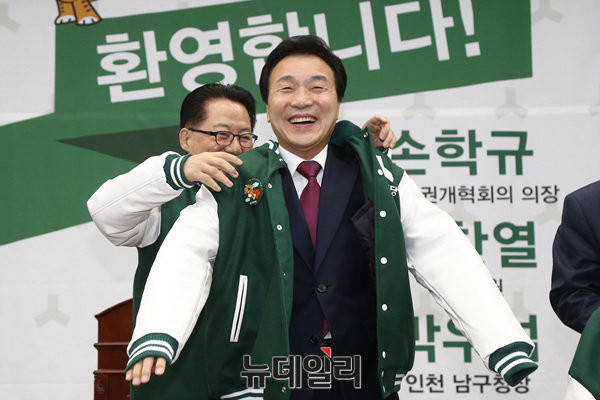 ▲ 지난 17일 국민의당 박지원 대표가 입당식에 참석한 손학규 전 대표에게 당 점퍼를 손수 입혀주고 있다. ⓒ국회 공동취재단