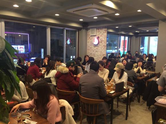 ▲ 굽네치킨의 일본 신오쿠보점 이미지. 사진은 굽네치킨 신오쿠보점에서 즐겁게 식사를 하는 일본인 고객 모습. ⓒ굽네치킨