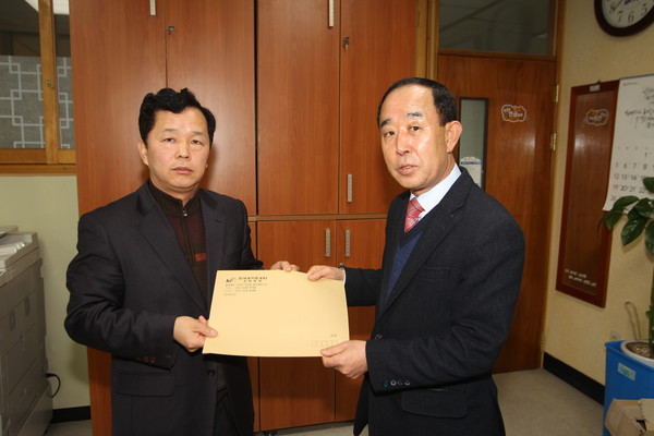 ▲ 농어촌공사 정윤재 진천지부장이 미군훈련장 저지 범 군민 대책위를 방문해 유재윤 대책위 상임대표에게  농어촌공사의 매입업무 불참에 대한 내용이 담긴 문서를 전달하고 있다.ⓒ진천군