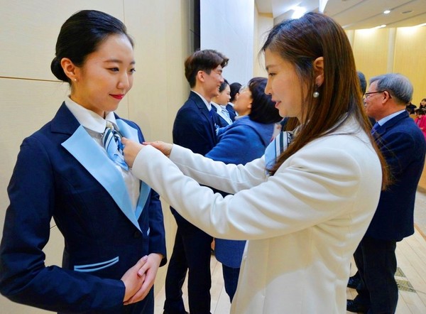 ▲ 교수와 학부모들이 항공서비스학과 신입생들에게 윙배지를 달아 주고 있다.ⓒ세명대