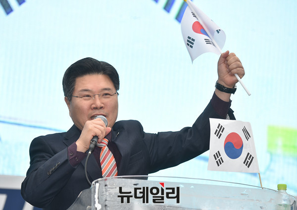 ▲ 자유한국당 홍문종 의원이 1일 태극기집회 연단에 올라 태극기를 휘날리며 탄핵 반대 연설을 하고 있다. ⓒ뉴데일리 이종현 기자